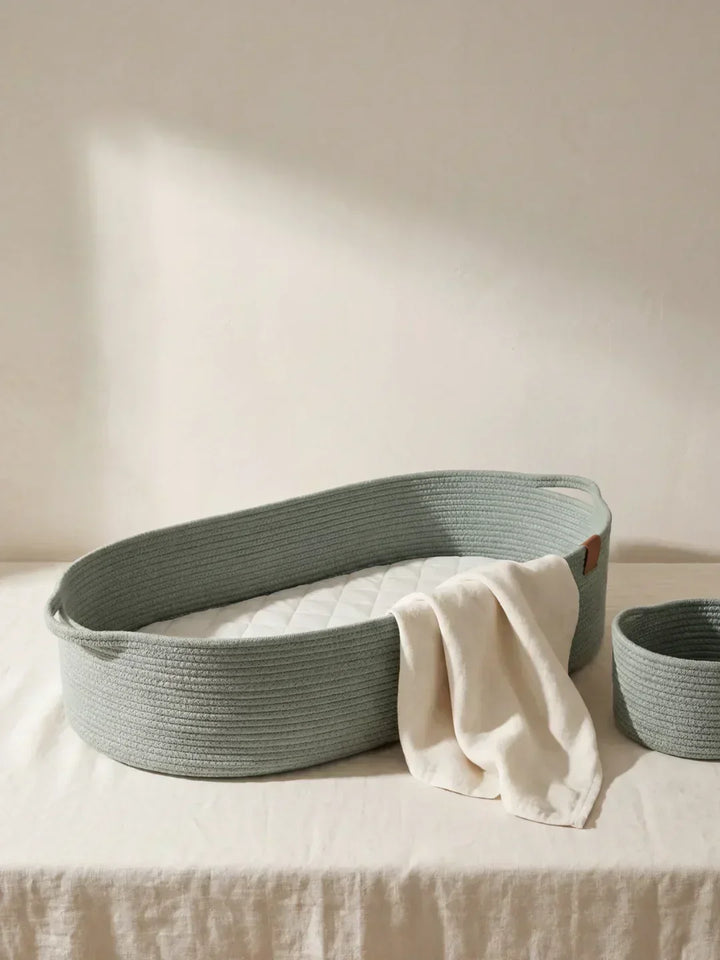 Cesto cambiador de algodón verde salvia con colchoneta. Ideal para organizar pañales y productos de bebé.