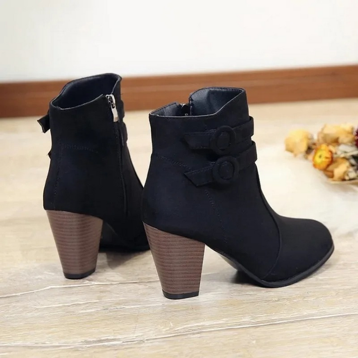 Primer plano de correas decorativas en botines de tacón alto para mujer. Piel sintética, estilo elegante.