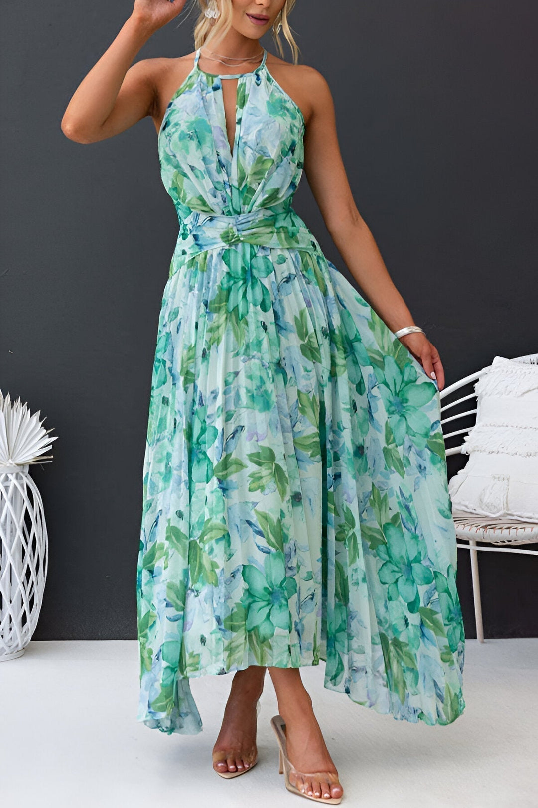 Mujer luciendo vestido maxi floral halter elegante, perfecto para vacaciones de verano. Plisado.