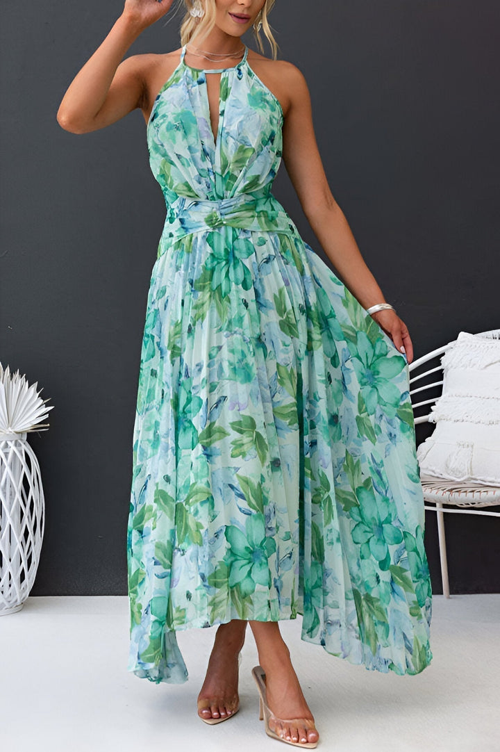 Mujer luciendo vestido maxi floral halter elegante, perfecto para vacaciones de verano. Plisado.