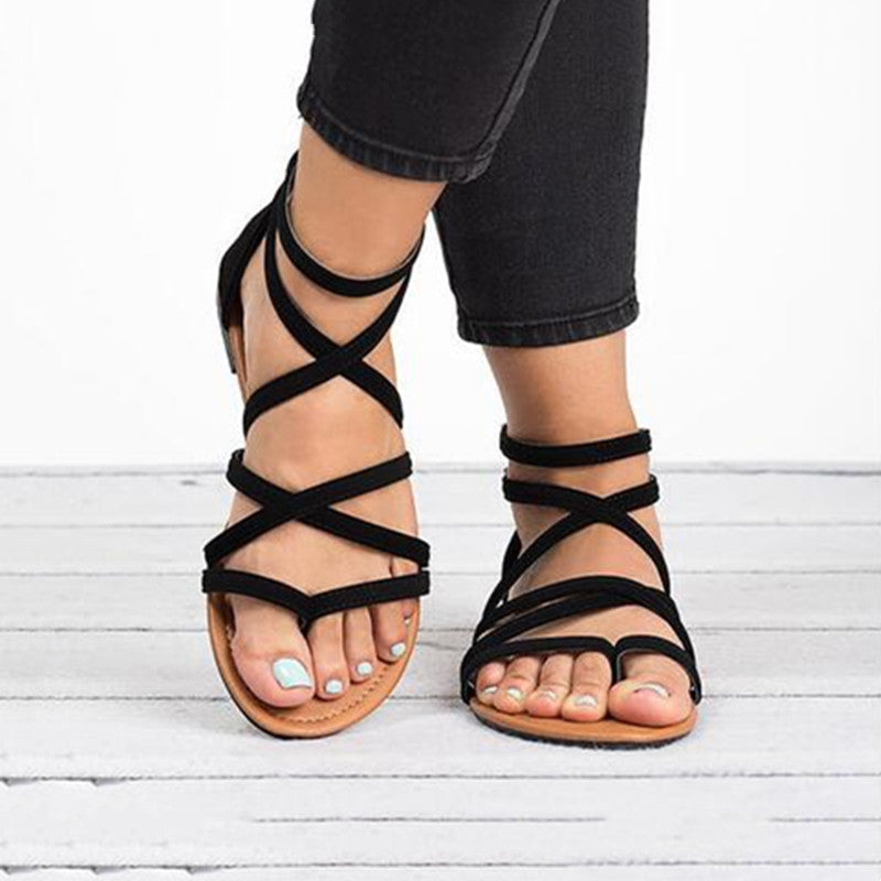Zapatos de playa para mujer: sandalias planas y elegantes con correas cruzadas, perfectas para un look de verano chic.