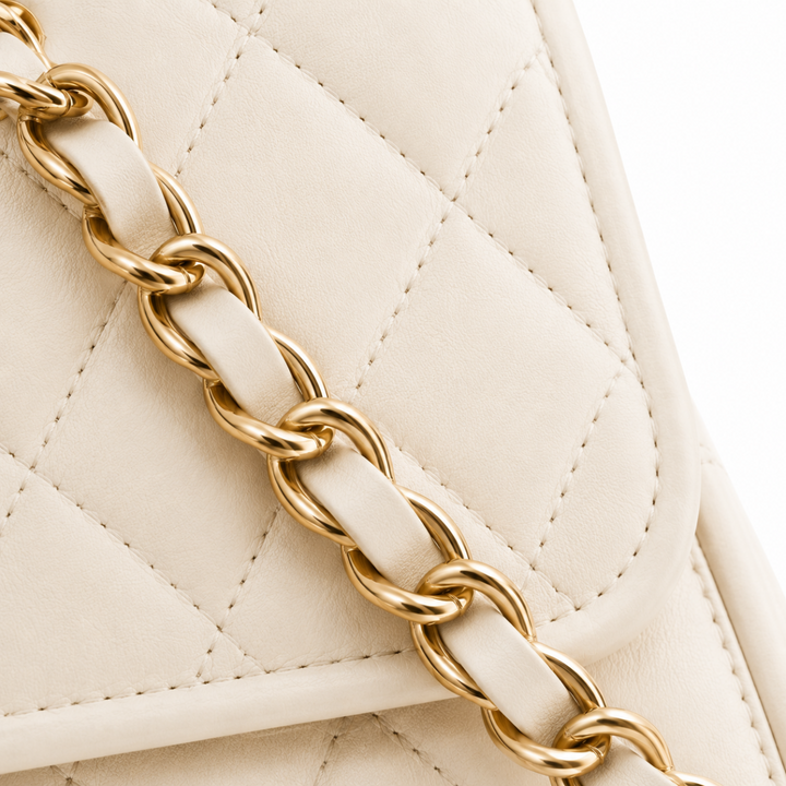 Bolso de hombro para mujer, sintético acolchado color crema, detalles de cadena dorada. Lujo y moda en un accesorio.