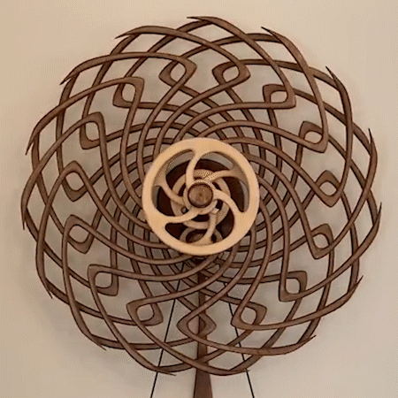 Escultura cinética de madera que crea un efecto visual relajante con su movimiento continuo. Ideal para meditación.