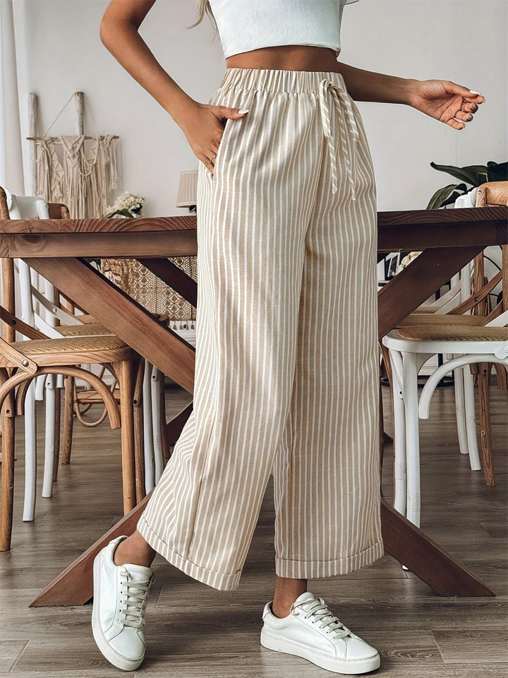 Primer plano de la textura del pantalón fluido de rayas, mostrando su ligereza y caída elegante. Ropa de mujer.