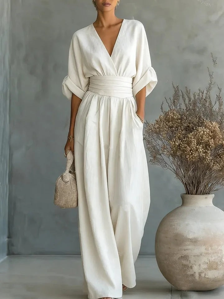 Mono elegante mujer con escote V y pantalón ancho de cintura alta, ideal para fiestas y ocasiones especiales.