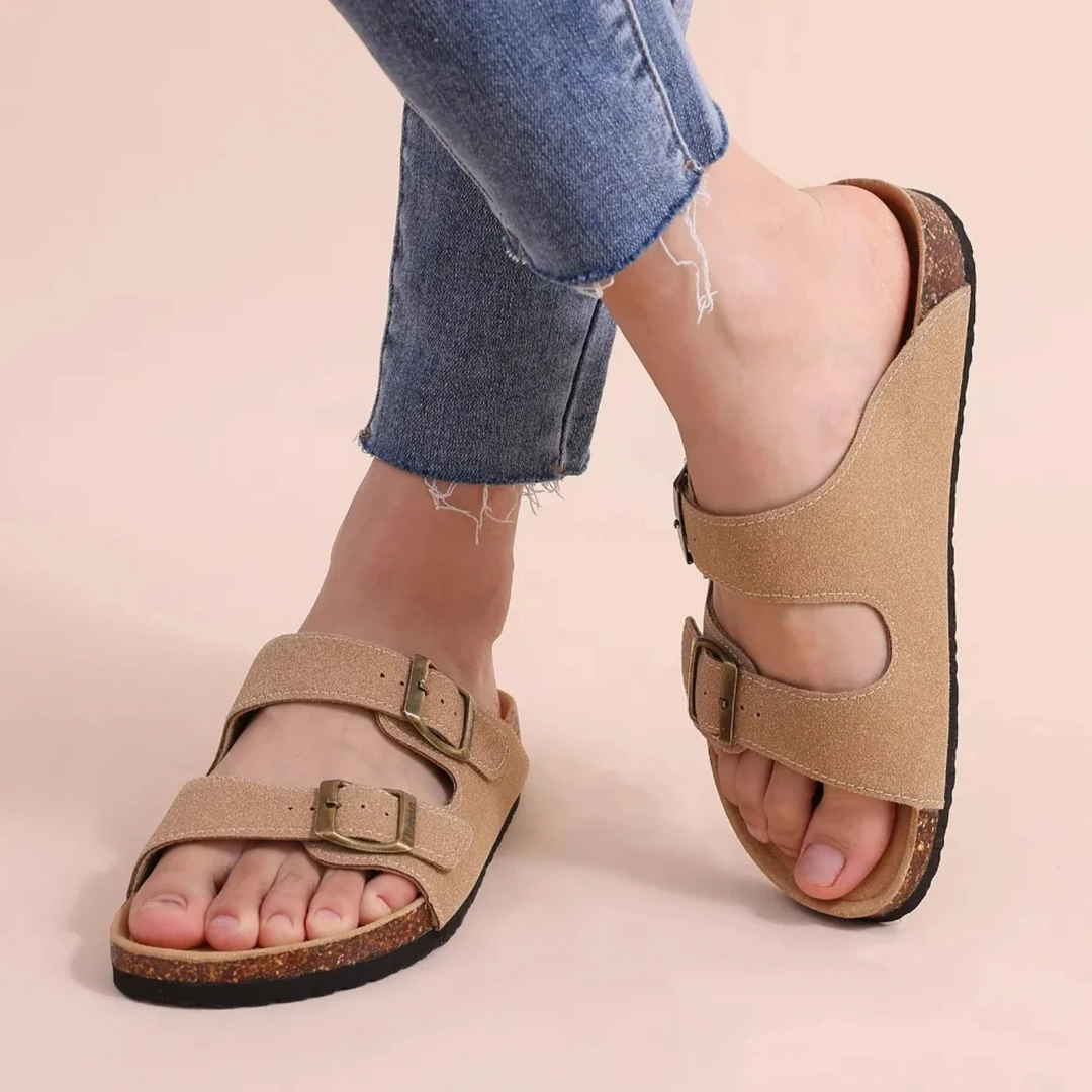 Detalle de sandalias de mujer con doble hebilla ajustable. Calzado de verano con punta abierta para comodidad.