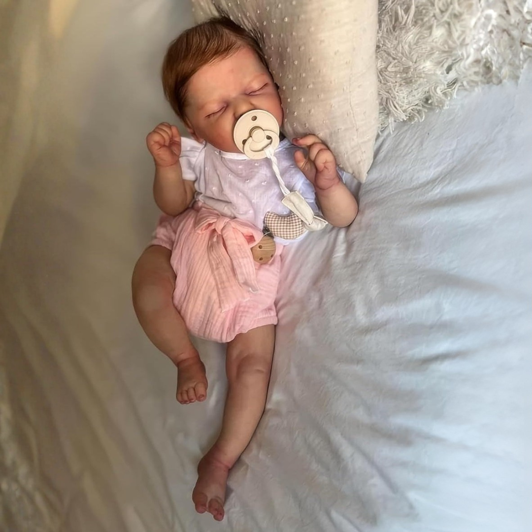 Muñeca bebé reborn de silicona suave en posición de dormir, juguete realista perfecto para niñas.