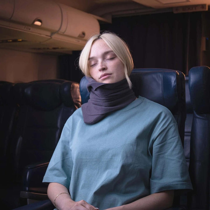 Almohada de viaje ergonómica para cuello, soporte envolvente y confort en avión o coche.