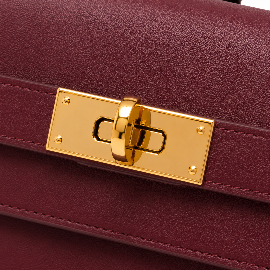 Bolso de mano burdeos de cuero sintético con cierre metálico, perfecto para moda y accesorios de mujer.