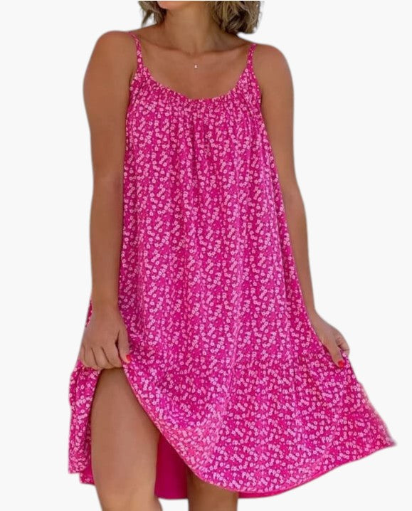 Mujer luciendo vestido de verano estampado, ligero y fluido. Estilo cómodo para la playa o ciudad en días cálidos.