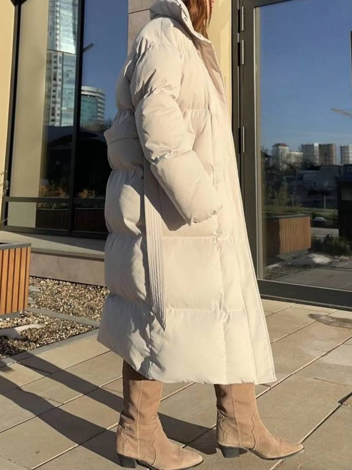 Moda mujer: abrigo acolchado largo con cinturón, diseño elegante para proteger del frío invernal.
