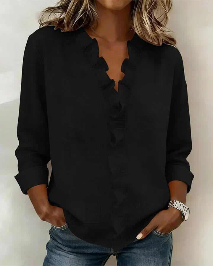 Blusa negra chic para mujer, con volantes sutiles, escote en V profundo y mangas largas.