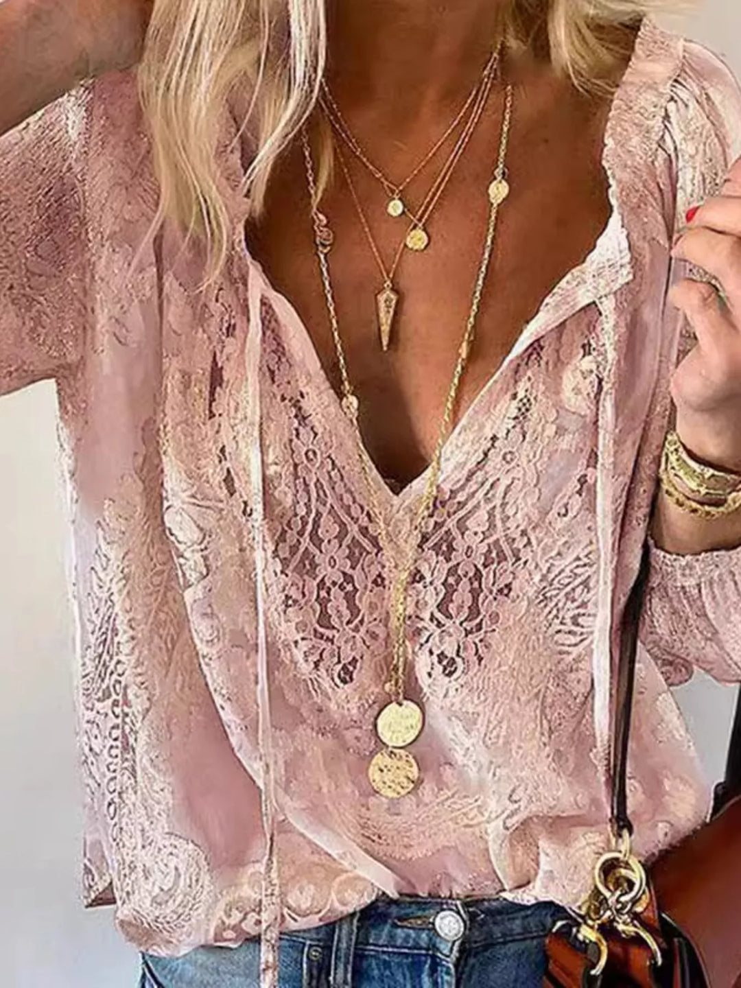 Blusa de encaje blanco con detalle de lazo en el cuello. Estilo romántico y versátil para mujer.