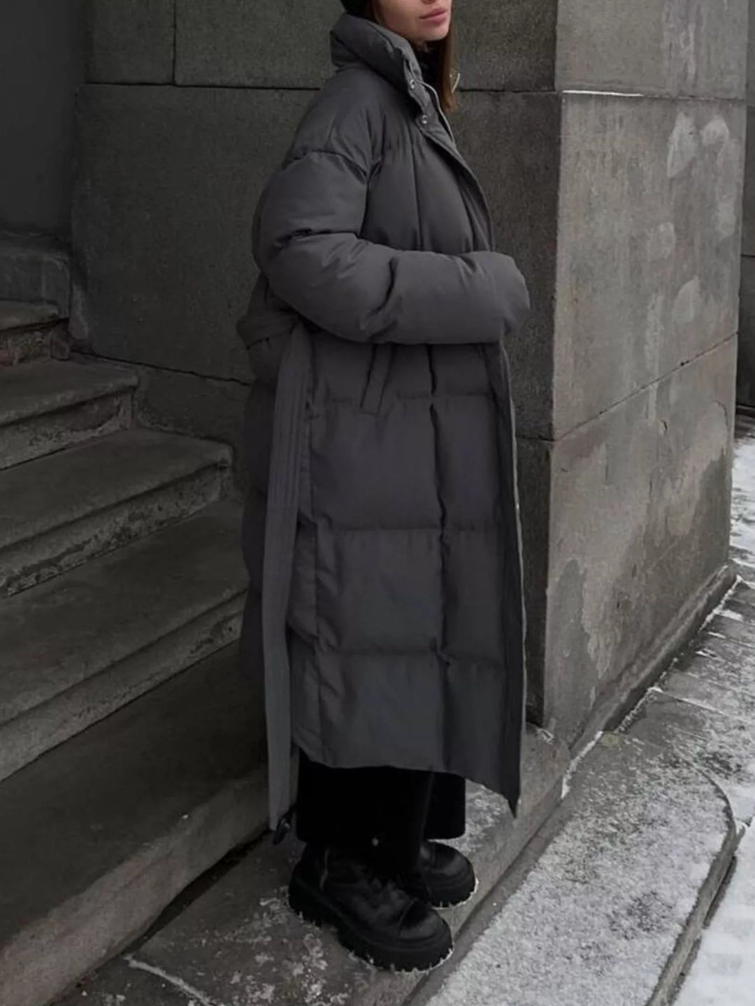 Chaqueta larga acolchada de mujer con cinturón en tonos tierra, ideal para combinar con cualquier atuendo.
