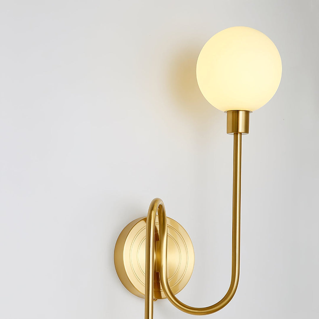 Lámpara de pared de latón con dos globos de cristal blanco. Ideal para pasillos o salones.