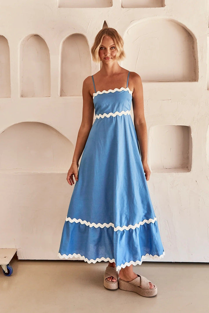 Atuendo de mujer: vestido largo fresco con tirantes y detalle de ondas, ideal para la playa.