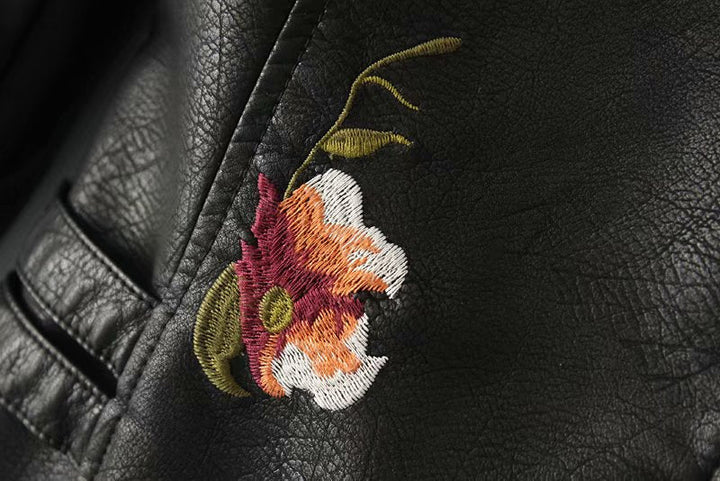 Chaqueta negra de cuero sintético para mujer con flores bordadas. Estilo biker único con tachuelas.