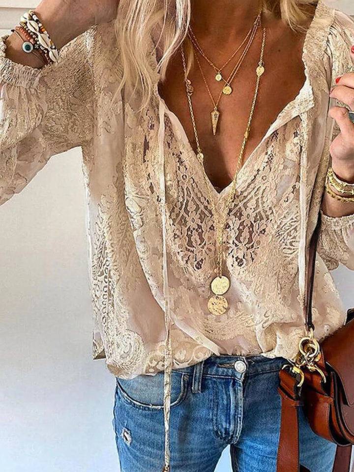 Blusa blanca de encaje con lazo en el cuello. Prenda romántica, femenina y de moda para mujer.