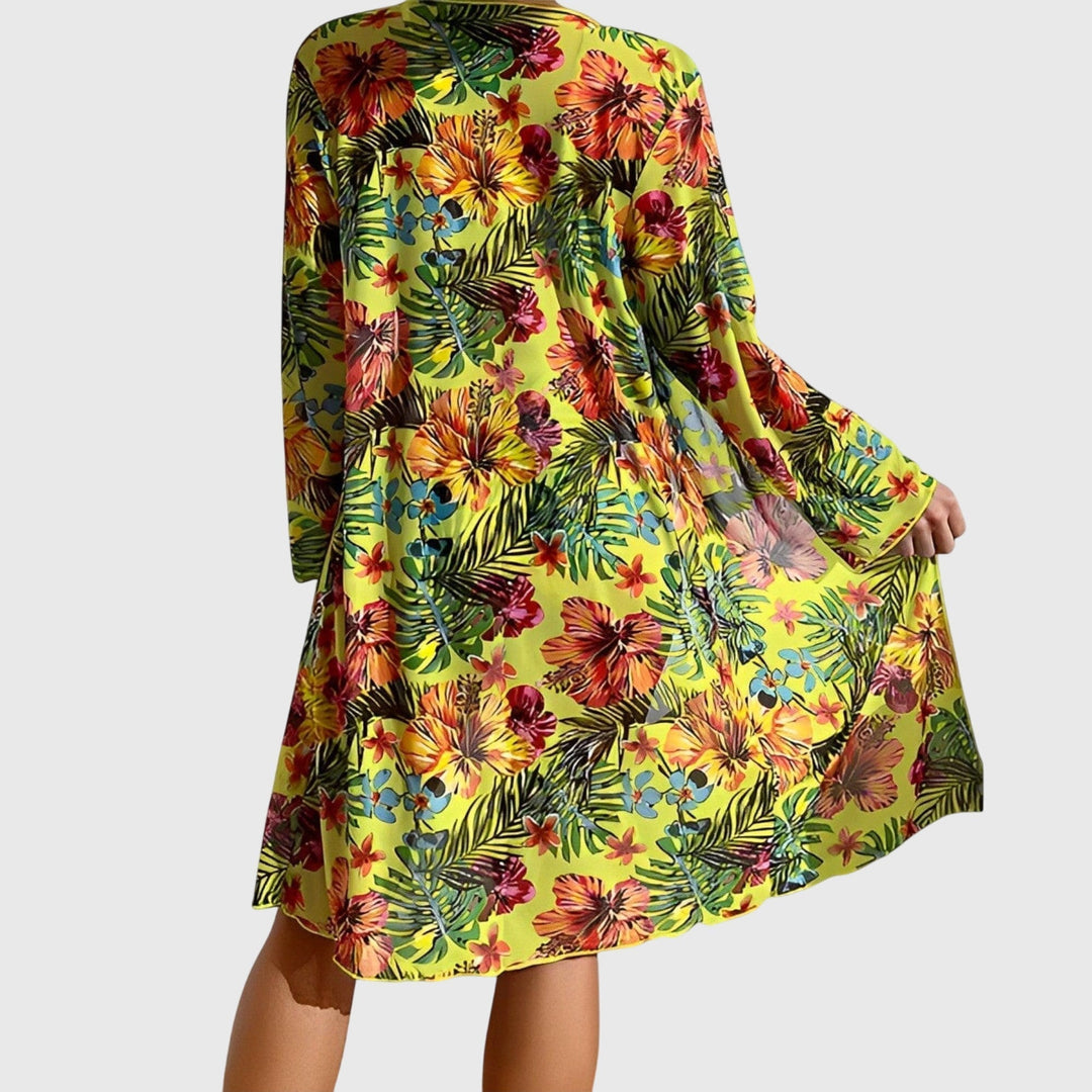 Mujer elegante en bikini tropical de tres piezas con top lazo y kimono estampado floral para la playa.