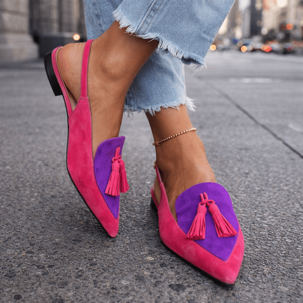 Mules modernos bicolores para mujer, con distintivos pompones y diseño de punta afilada, ideal para moda actual.