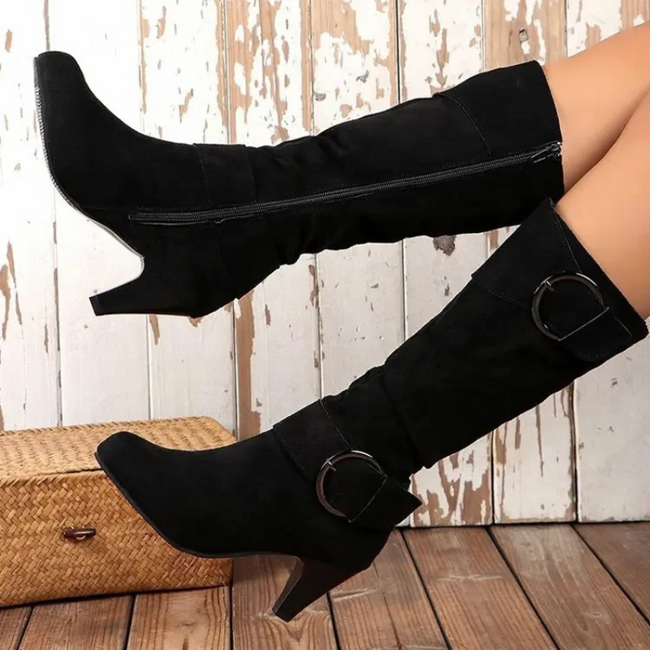 Detalle de la cremallera lateral en botas altas de mujer, puntera redonda, estilo elegante.