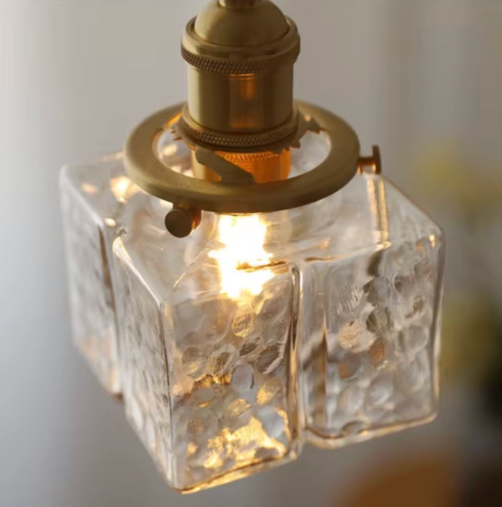 Lámpara colgante vintage encendida, vidrio texturizado y latón, luz cálida interior E27.