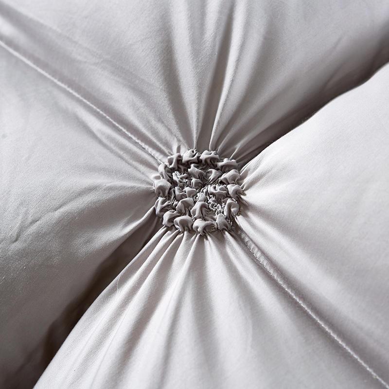 Manta de plumón ultraligera sobre cama de dormitorio. Estilo elegante, aporta confort y calidez al hogar. Diseño premium.