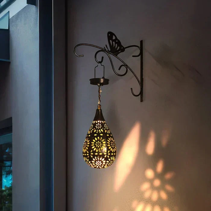 Primer plano de lámpara solar floral para jardín, detalle de pétalos y luz cálida. Perfecta para decoración nocturna.