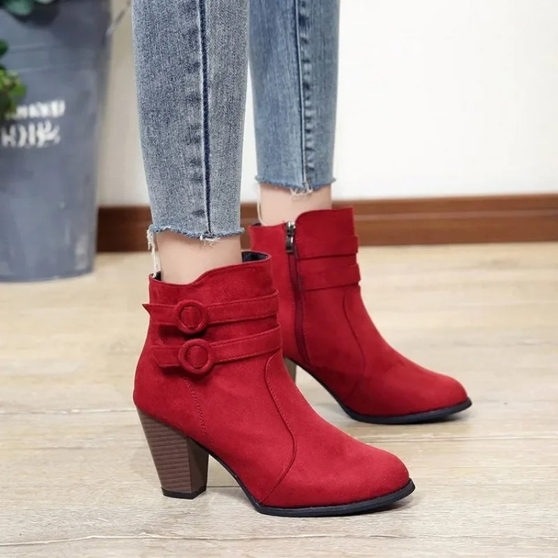 Par de botines de tacón alto para mujer con correas decorativas. Calzado versátil para ocasiones casuales o formales.