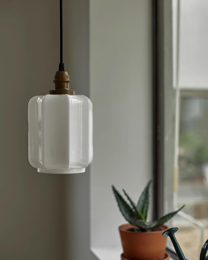 Lámpara colgante moderna y elegante, con pantalla de cristal blanco lechoso y detalles en latón.