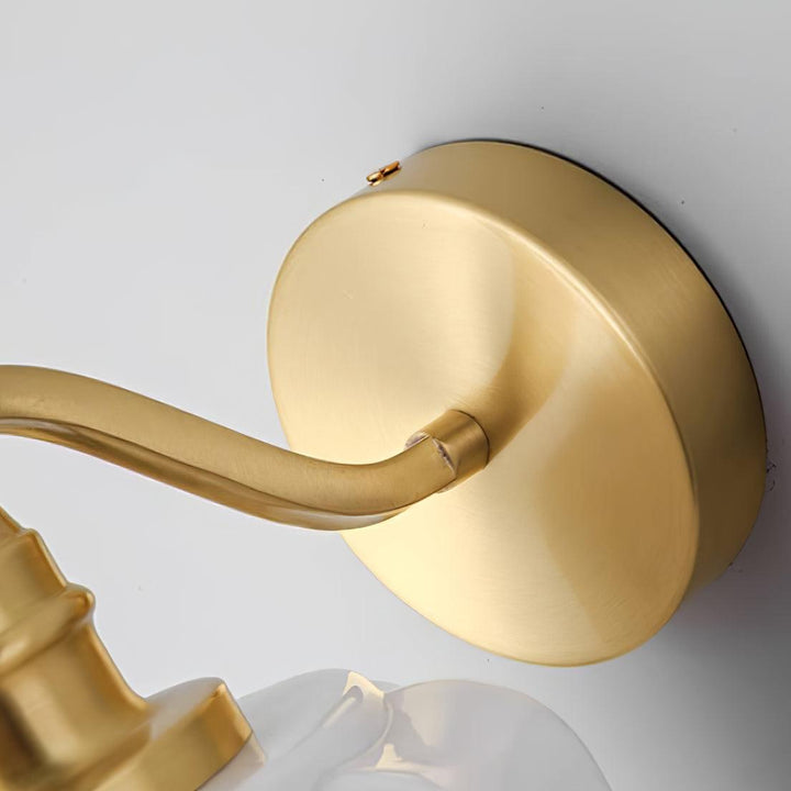 Aplique compacto de pared con estructura de latón y difusor de cristal.