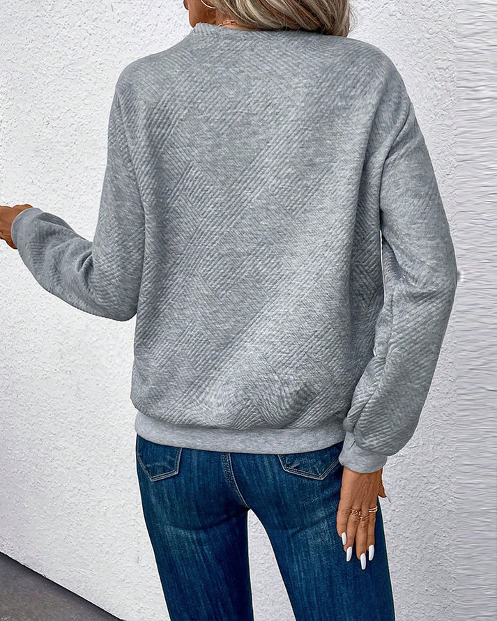 Mujer posando con jersey clásico, diseño elegante y cómodo. Pullover versátil para looks casuales de invierno.