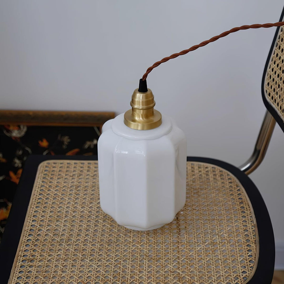 Suspensión de diseño con cristal blanco esférico y detalles en latón. Elegante y moderno.