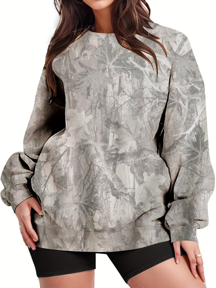 Mujer luciendo sudadera oversize camuflaje. Vista frontal, look casual urbano y relajado.