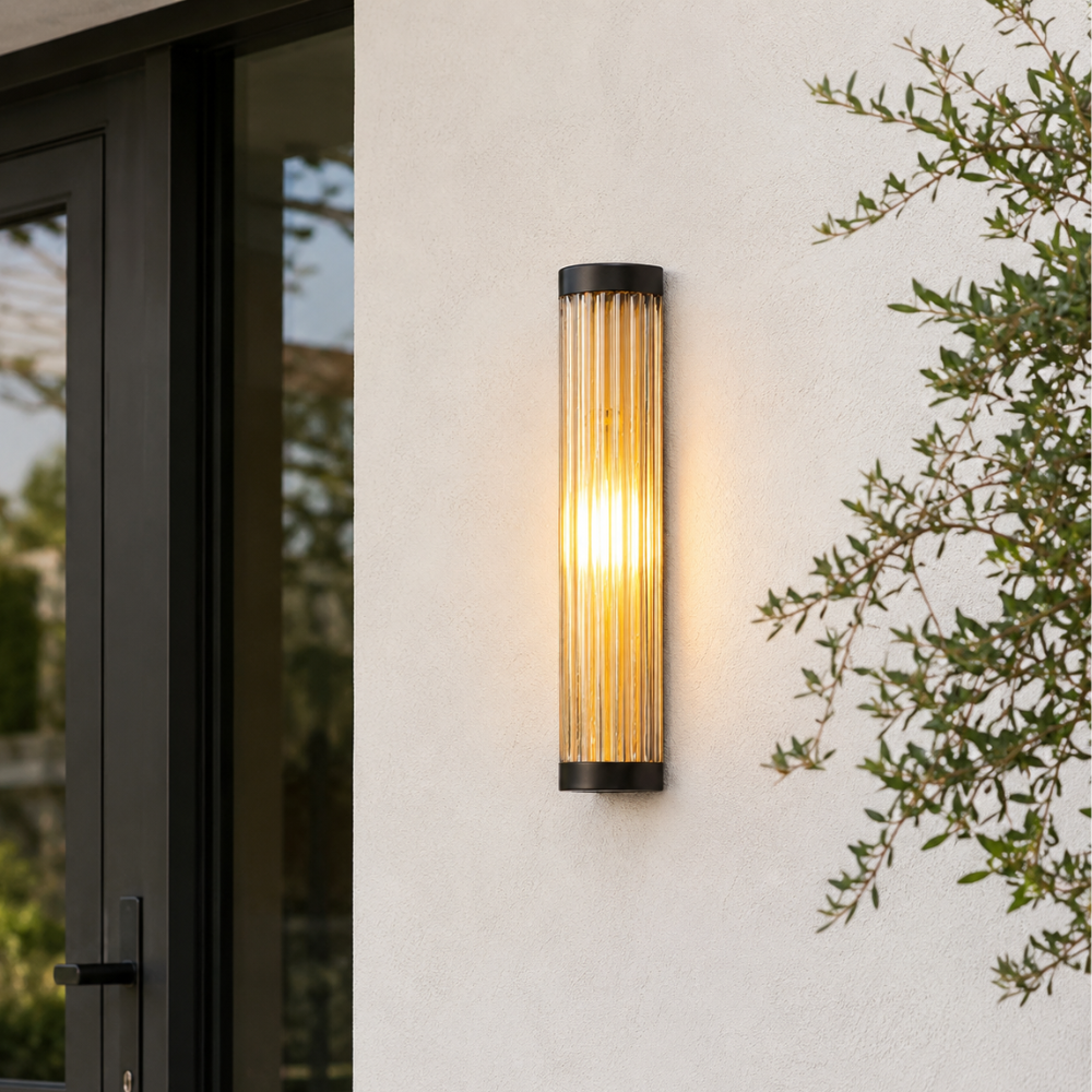 Aplique cilíndrico para iluminación exterior, resalta la belleza de jardines y patios.