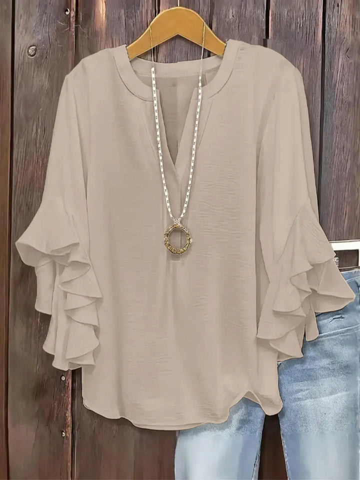 Blusa sofisticada para mujer, escote V y mangas acampanadas. Destaca en moda femenina actual.