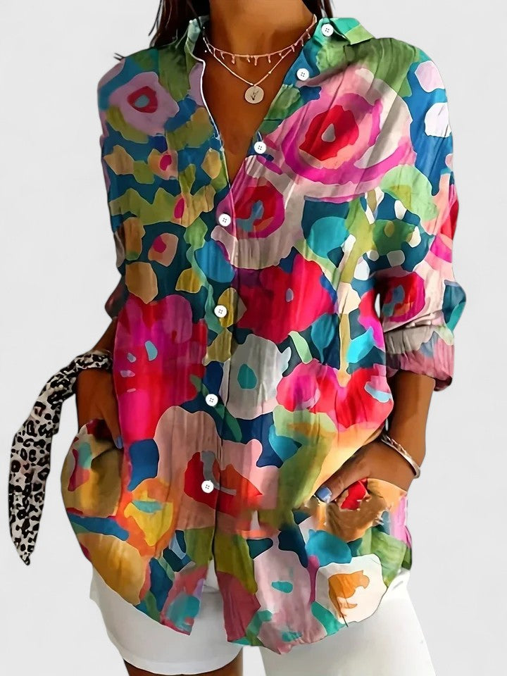 Mujer vistiendo camisa estampada floral de manga larga, diseño casual y moderno para primavera-verano.