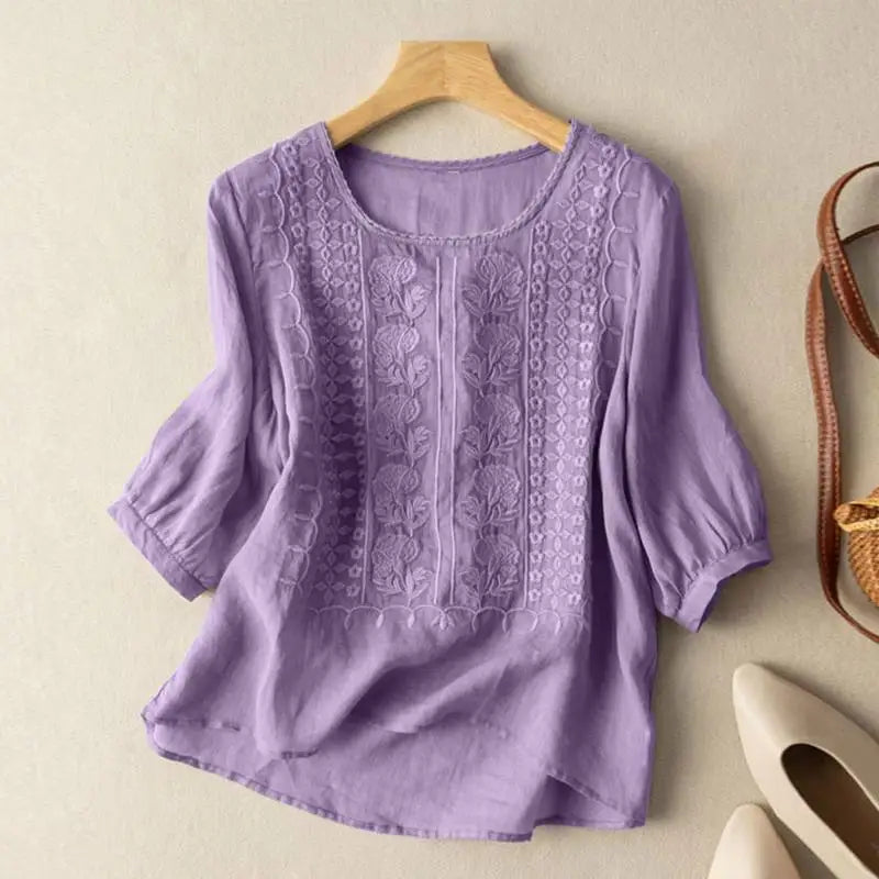 Detalle de blusa bordada de mujer con manga tres cuartos. Diseño fresco y chic para ropa femenina de verano.