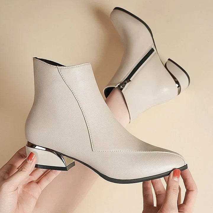 Detalle de cremallera lateral en botines de mujer, con tacón bajo y elegante punta puntiaguda.