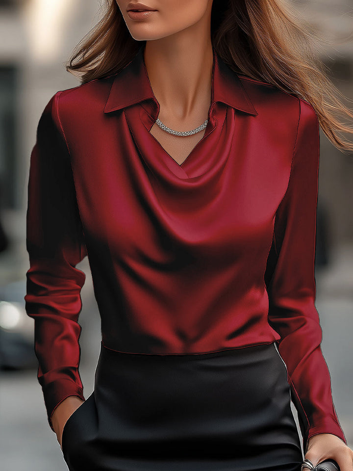 Mujer posando con blusa elegante de cuello cowl y manga larga, realzando su figura. Estilo femenino.