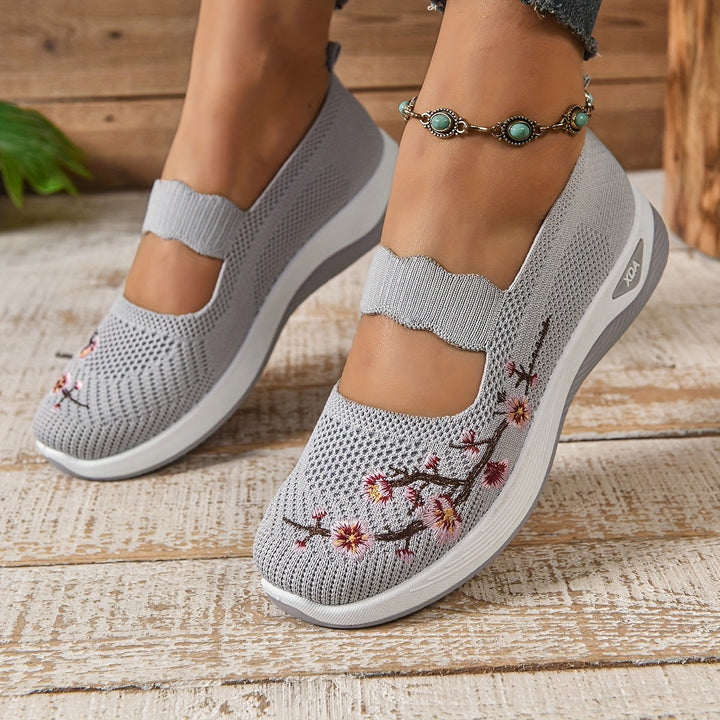 Zapatillas Mary Jane de punto con detalles florales. Estilo slip-on y confort para la mujer moderna.