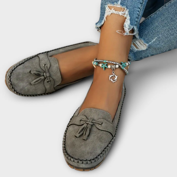 Elegantes mocasines casuales de ante con flecos y detalle de tobillera para mujer. Calzado cómodo y versátil.