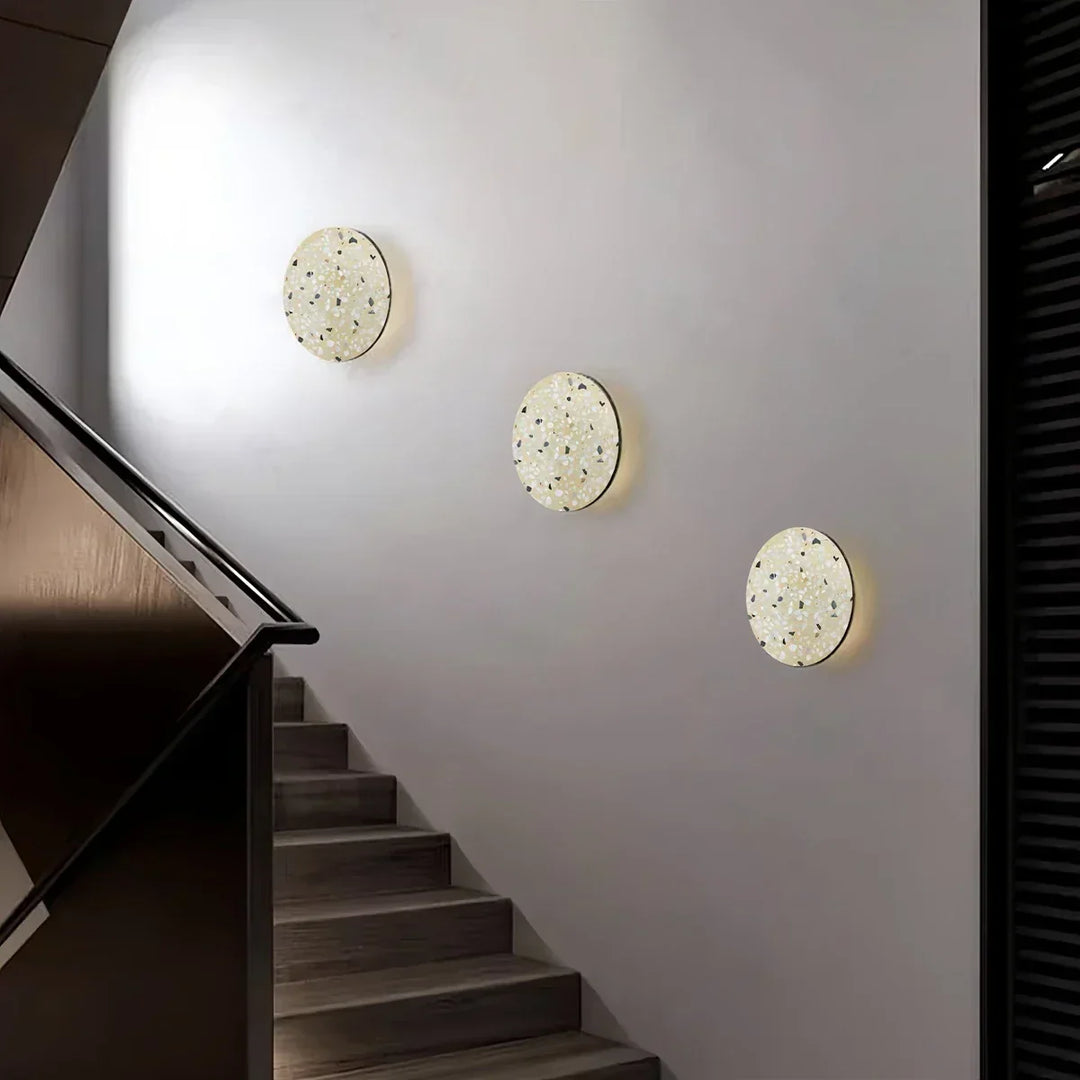 Lámpara de pared moderna de terrazo, con halo luminoso para un ambiente acogedor.