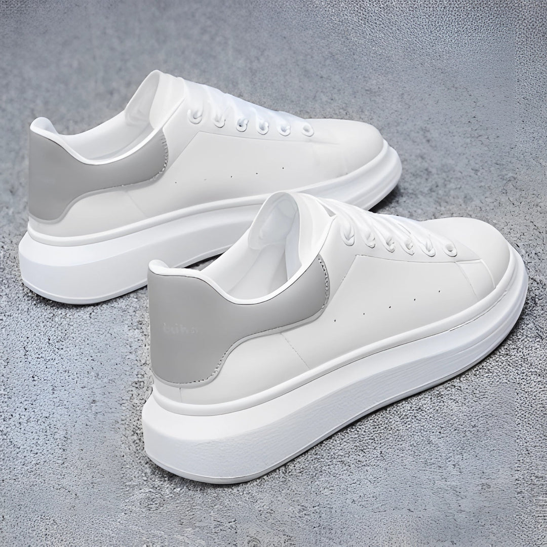 Par de zapatillas blancas de hombre con suela de plataforma gruesa. Calzado moderno y cómodo para estilo urbano y casual.