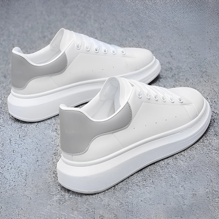 Par de zapatillas blancas de hombre con suela de plataforma gruesa. Calzado moderno y cómodo para estilo urbano y casual.