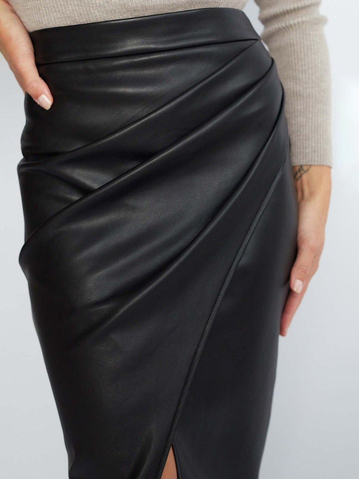 Detalle de falda plisada blanca de mujer con abertura. Estilo fresco y moderno para verano.