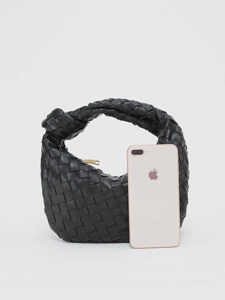 Detalle de tejido trenzado en bolso de mano para mujer, muestra la textura única y el estilo chic.