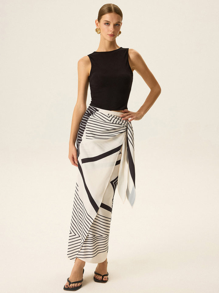 Look veraniego mujer: top blanco sin mangas y falda estampada floral. Conjunto fresco y chic para el sol.