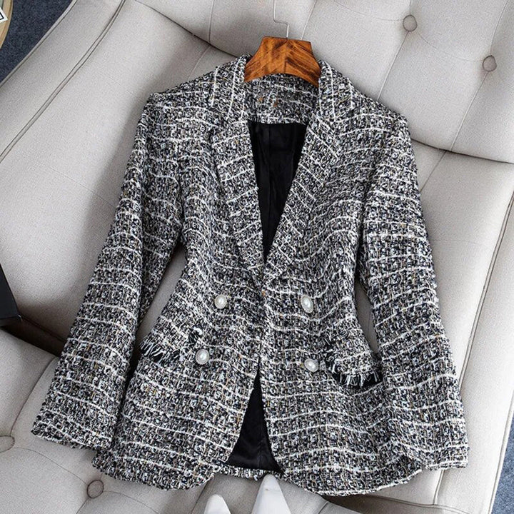 Modelo vistiendo blazer entallado negro con encaje y cuadros, resaltando su corte elegante y moderno.