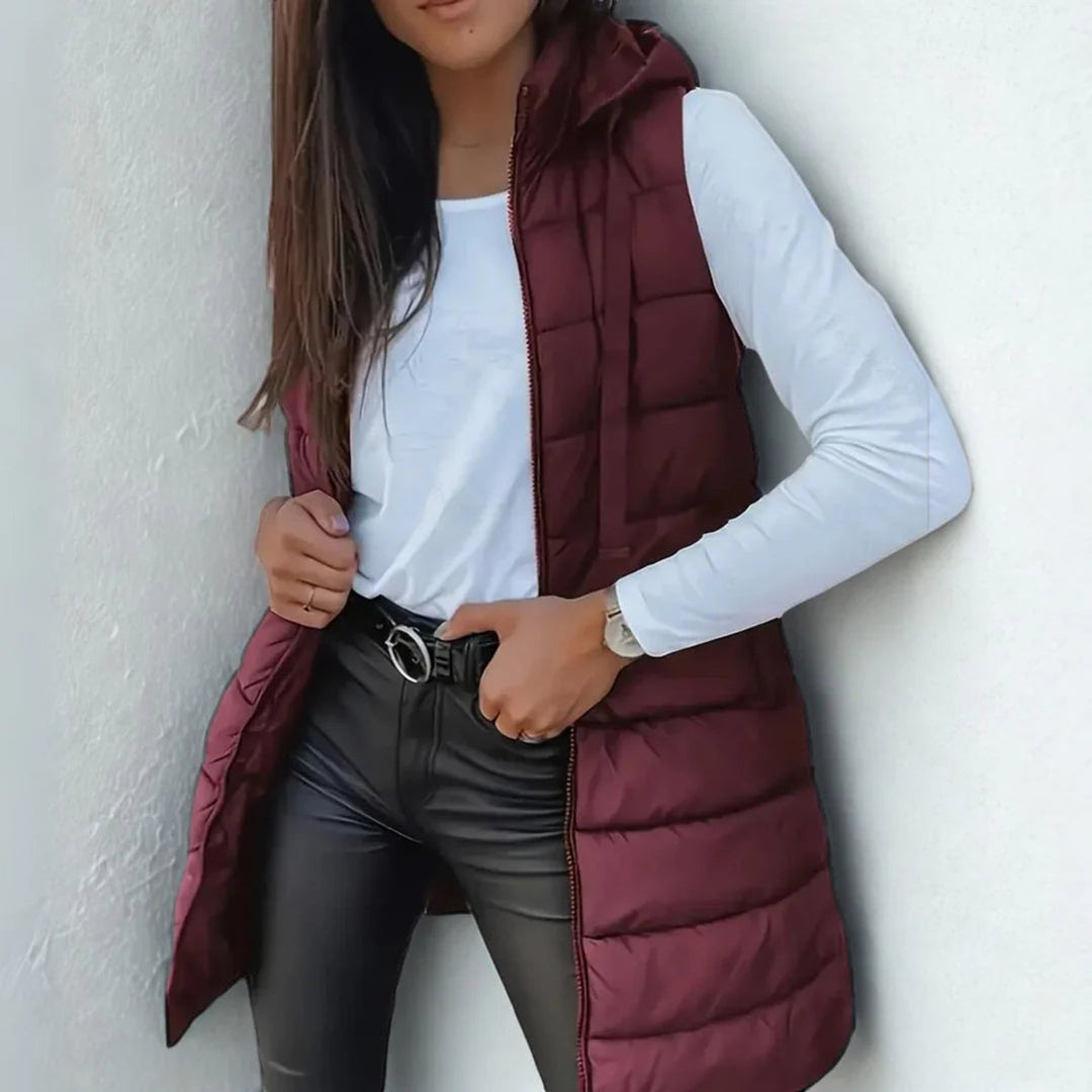 Chaleco largo de mujer con capucha y acolchado. Diseño elegante y cómodo para el frío invernal.
